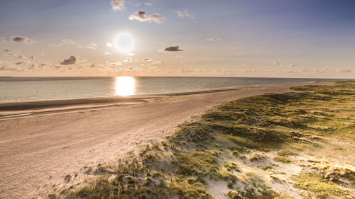 Scenic view of beach against sky during sunset