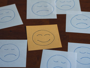 Close-up of text notes with happy face among sad faces