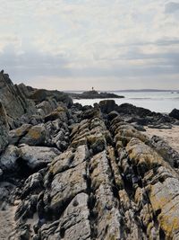 Rock formation on beach against sky