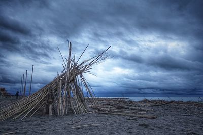 Windmill on beach against sky