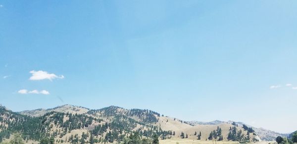 Scenic view of mountains against blue sky