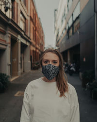 Portrait of young woman standing in city