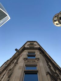 Low angle view of buildings against clear blue sky