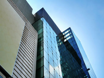 Low angle view of modern buildings against clear blue sky