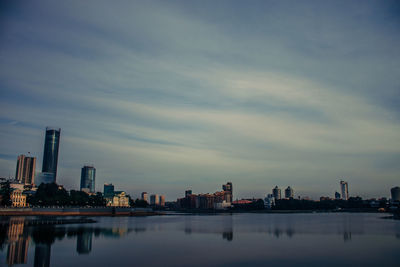 Reflection of buildings in city against sky