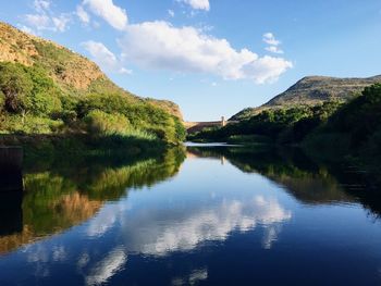 Scenic view of hartbeespoort dam with clouds reflection in river