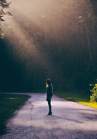 Full length of woman on road amidst trees