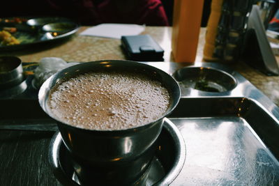 Close-up of coffee in stainless steel glass on plate