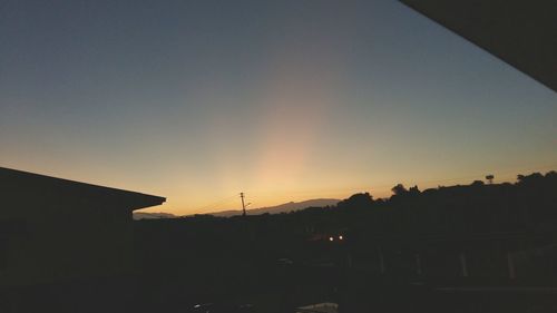 Low angle view of silhouette built structure against sky at sunset