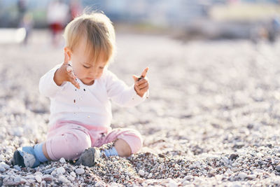 Full length of cute girl on pebbles at beach