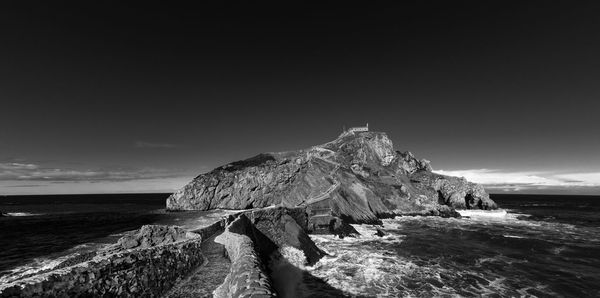 Panoramic shot of rocks on beach against sky