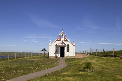 Traditional windmill on field against sky