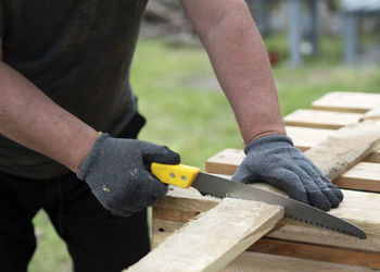 Midsection of man working on wood