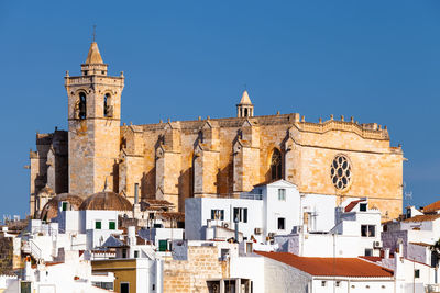 Buildings in city against clear blue sky