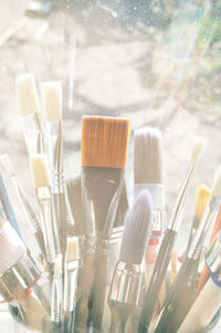 Close-up of paintbrushes against glass window