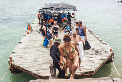 People sitting on pier over lake