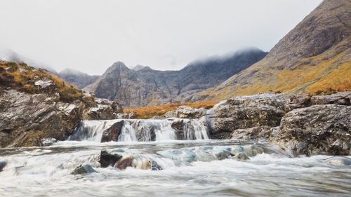 Scenic view of waterfall against sky