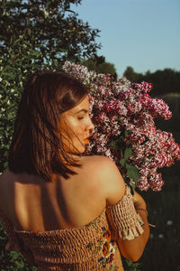 Beautiful woman standing by flowering plants