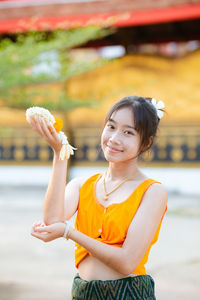 Portrait of smiling young woman holding drink