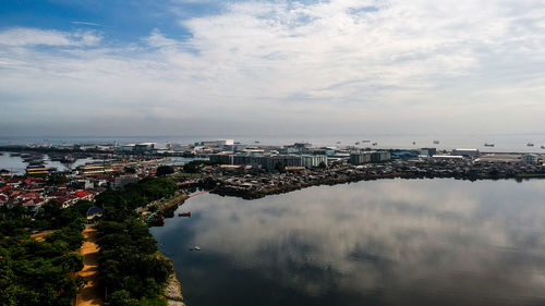 High angle view of townscape by sea against sky