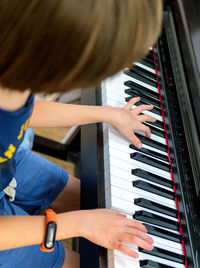 Midsection of boy playing piano