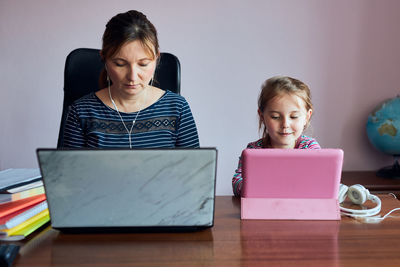 Woman mother working doing her job remotely during video chat call stream online course