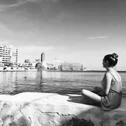 Side view of woman looking at sea against sky