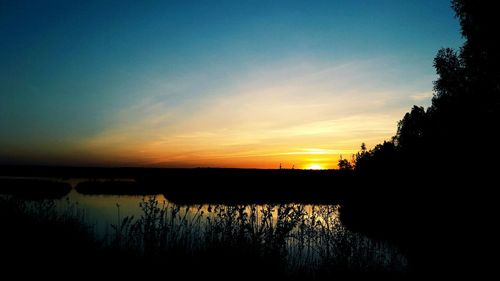 Scenic shot of calm lake at sunset
