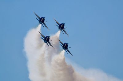 Low angle view of airshow against sky