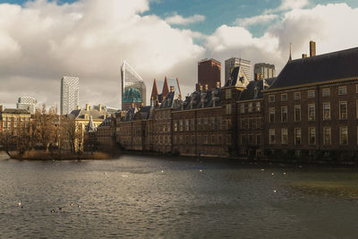 River by buildings against sky in city