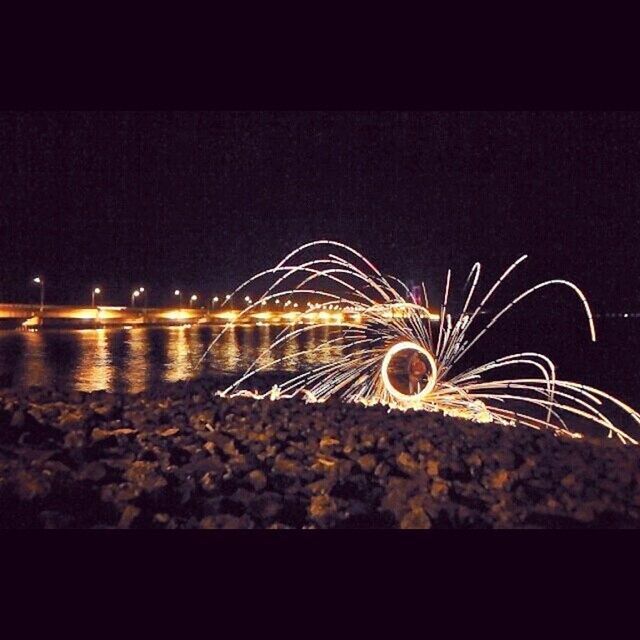 night, illuminated, long exposure, motion, copy space, glowing, light trail, clear sky, arts culture and entertainment, dark, blurred motion, sky, outdoors, light - natural phenomenon, pattern, no people, street, speed, light, light painting