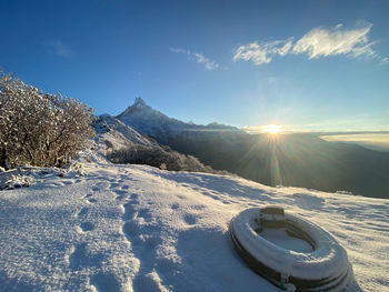 Scenic view of snow covered mountains against sky on sunny day