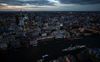 Captured from the shard, the shimmering lights of london's financial district and thames  at night