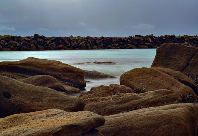 Rocks on beach against sky