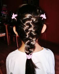 Rear view of girl with braided hair standing at home