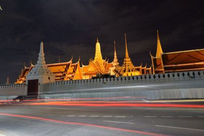 Light trails on street against illuminated wat phra kaew