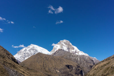 Scenic view of snowcapped mountains against blue sky