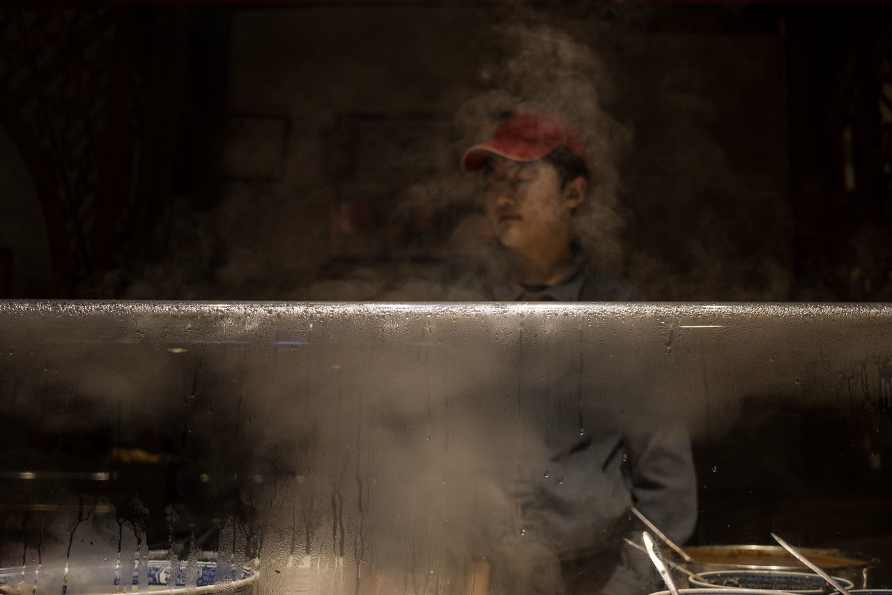 real people, indoors, occupation, one person, working, smoke - physical structure, adult, preparation, men, waist up, business, steam, looking away, preparing food, lifestyles, window, looking, architecture