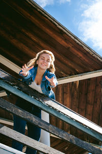 Low angle view portrait of woman standing at observation point against sky