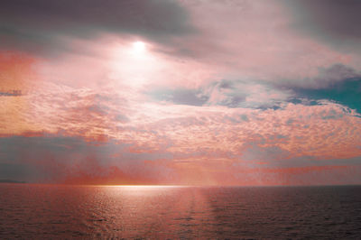 Beautiful magical dramatic sunset over the sea, pink background.