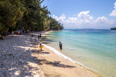 People on beach against sky