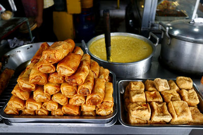 Filipino food called fried mung bean sprouts in spring roll wrapper, fried tofu and rice porridge.