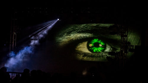 Person looking at illuminated car against sky at night