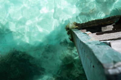 Wooden ladder on calm summer tropical sea with sparkling water in semporna, sabah.