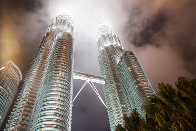 Low angle view of modern buildings against cloudy sky