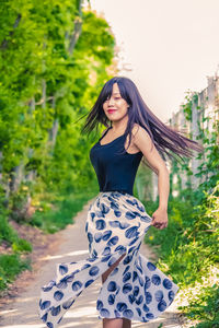 Portrait of a smiling young woman against plants