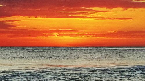 Scenic view of sea against orange sky