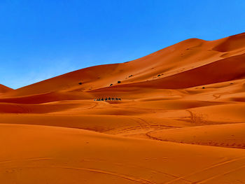 Scenic view of desert against clear blue sky