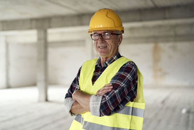 Senior architect with arms crossed at construction site