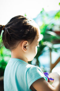 Portrait of adorable toddler girl playing in the park, view from behind.